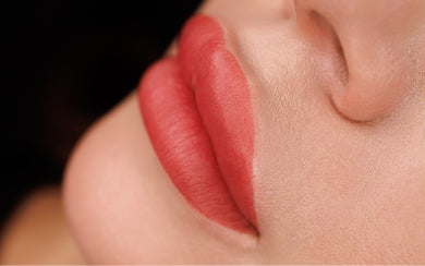 Close-up profile of lips featuring a vibrant red lip blush tattoo highlighting strong PMU pigment retention.