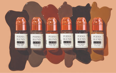 Six Perma Blend LUXE pigment bottles lined up over rich brow color swatches.